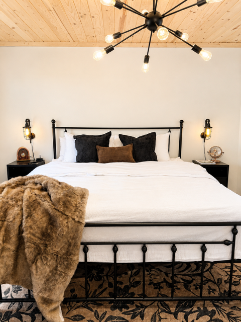 King Suite — black metal bed frame with sputnik chandelier