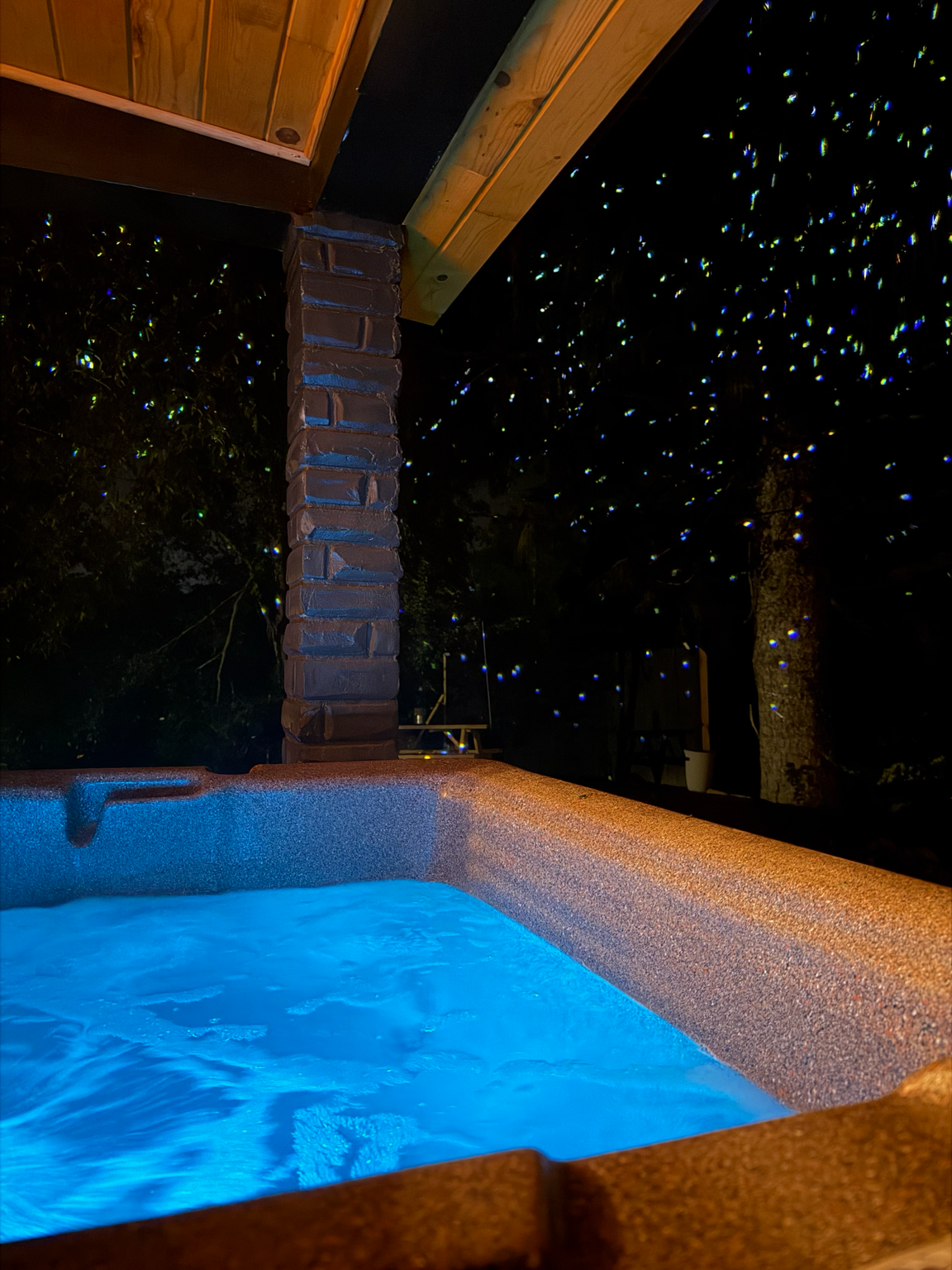 Hot tub glowing blue at night — The Lantern