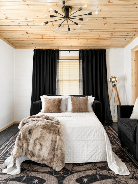 Living area — wooden ceiling and black curtains