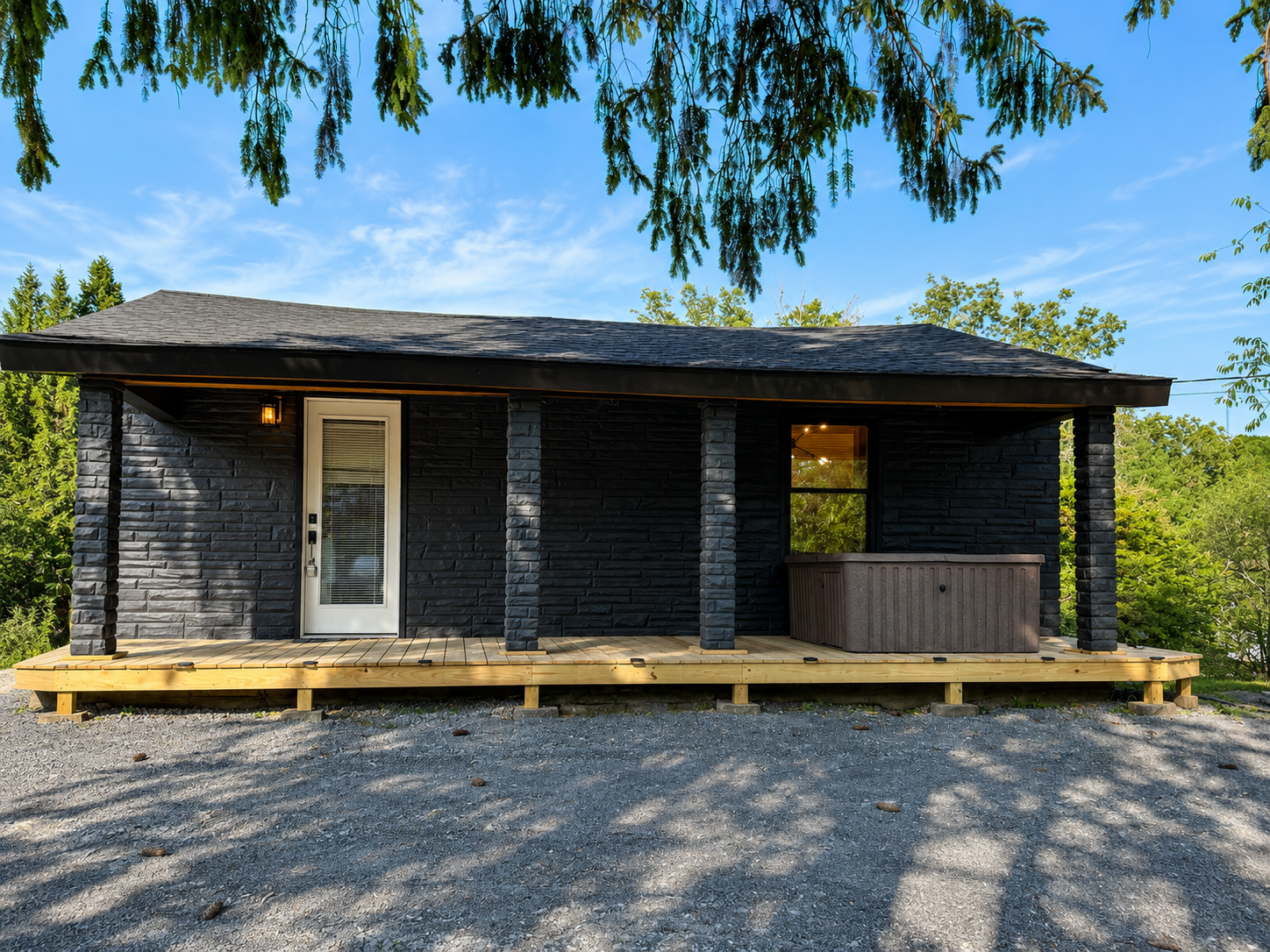 The Lantern — black cabin with wooden deck porch