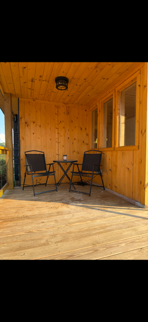 The Lantern — wooden cabin porch with seating area